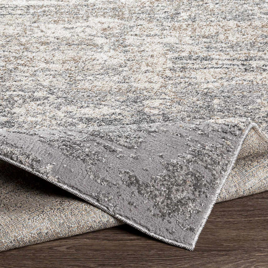 Close-up of the Kyabram textured abstract area rug showing beige, charcoal, gray, and off-white tones. Fold