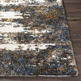 Close-up of the shag Lafontaine Boutique Area Rug. Cream, blue, brown, and mustard colors on a dark wood floor. Front