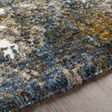 Close-up of the Lafontaine Boutique Area Rug, a shag rug with cream, blue, brown, gray, and mustard colors. Texture