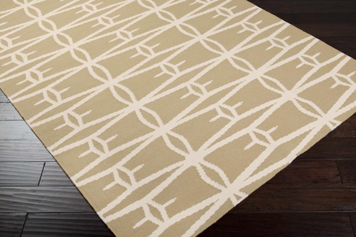 Close-up of a tan and peach Lambourn Area Rug with a geometric, contemporary design on dark wood flooring. Corner