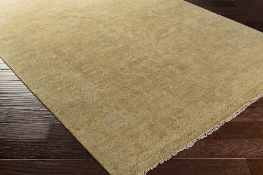 Close-up of the hand-knotted Langhorne Carpet in mustard on dark wood floors. 100% NZ Wool rug with traditional farmhouse style. Corner