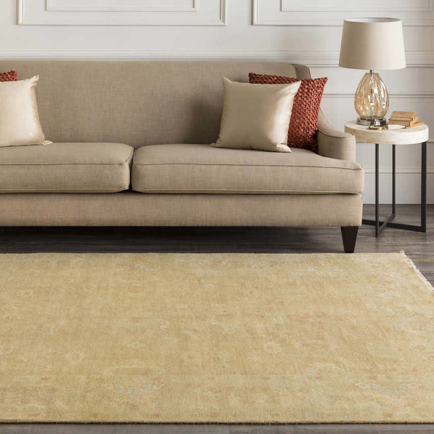 Living room scene with a tan sofa and the Langhorne Carpet in dusty pink and mustard tones. Roomscene-Rectangle