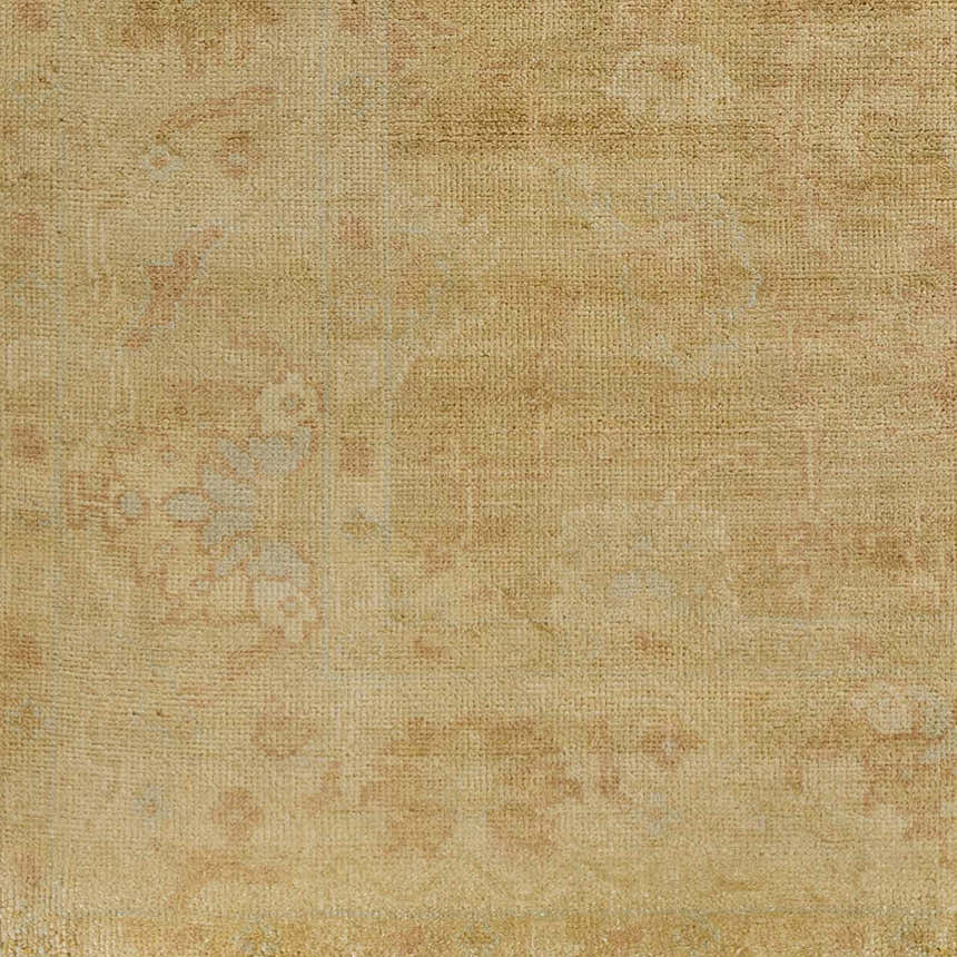 Close-up of the hand-knotted Langhorne Carpet, a traditional rug in tan, dusty pink, and mustard tones. Wool texture detail. Swatch