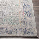 Close-up of the Laplace Area Rug showing its traditional blue, gray, and mustard vintage-inspired pattern and soft texture. Front