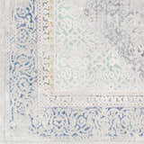 Close-up of the Laplace Area Rug showing its traditional, vintage pattern in blue, charcoal, sage, and light gray. Swatch