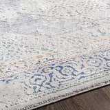Close-up of the Laplace Area Rug, showing its vintage-style pattern in blue, gray, and hints of mustard. Soft texture. Texture