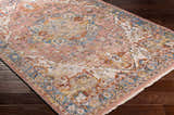 Close-up of the Lappe Area Rug on dark wood floor. Features cream, blue, and rust colors in a traditional pattern. Corner