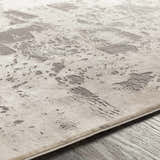 Close-up of the Lares Area Rug showing its light beige base and charcoal, mid-century modern pattern. Texture