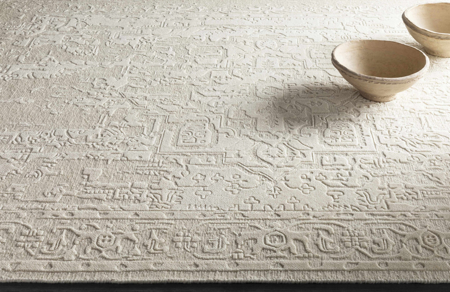 Close-up of the hand-knotted Larimer Area Rug. Cream wool rug with a raised, vintage-inspired geometric pattern. Styleshot