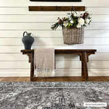 Entryway with a dark gray Athor Washable Rug, wood bench, throw blanket, and floral basket. Farmhouse style. Roomscene-Rectangle