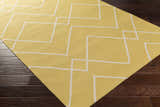 Close-up of the hand-woven Leatherwood Area Carpet. Off white geometric pattern on a tan, 100% cotton rug. Contemporary style. Corner