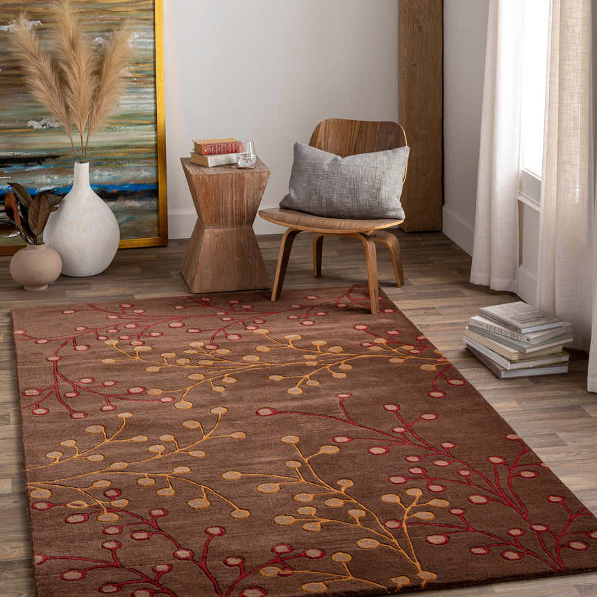 Living room scene with a brown Elsu Area Rug featuring a red and gold floral design on wood floors. Roomscene-Rectangle