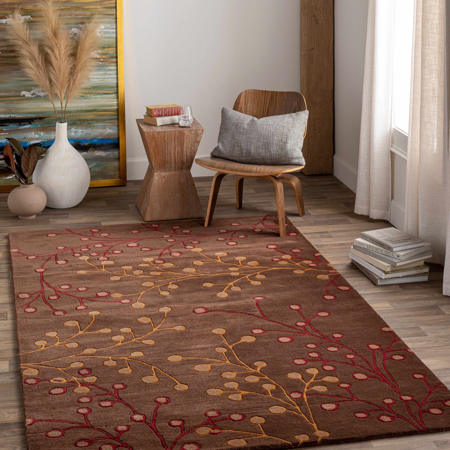 Living room scene with a brown Elsu Area Rug featuring a red and gold floral design on wood floors. Roomscene-Rectangle