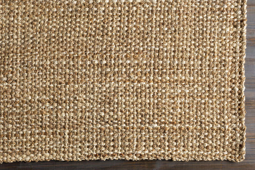 Close-up of the hand woven Leyton Natural Jute Rug showing texture and natural ivory and tan color variations. Corner