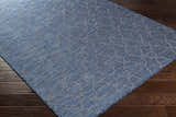 Close-up of the blue Lidlington Flatweave Area Carpet showing its geometric pattern and flat weave texture on a wood floor. Corner