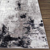Close-up of the Limao Abstract Denim Area Rug showing its cream, gray, and black abstract pattern and soft texture. Front