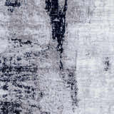 Close-up of Limao Abstract Denim Area Rug showing its gray, cream, and denim abstract pattern and soft polyester texture. Swatch