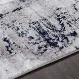 Close up of Limao Abstract Denim Area Rug showing texture and abstract denim and gray pattern. Texture