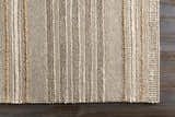 Close-up of the hand woven Allendorf Area Rug. Beige, cream, and charcoal stripes with natural fiber accents. Corner