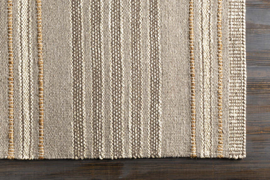 Close-up of the hand woven Allendorf Area Rug. Beige, cream, and charcoal stripes with natural fiber accents. Corner