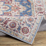 Close-up of the Kapaa Blue Medallion Rug, showcasing its beige, blue, and burgundy traditional floral pattern and machine-woven texture. Fold