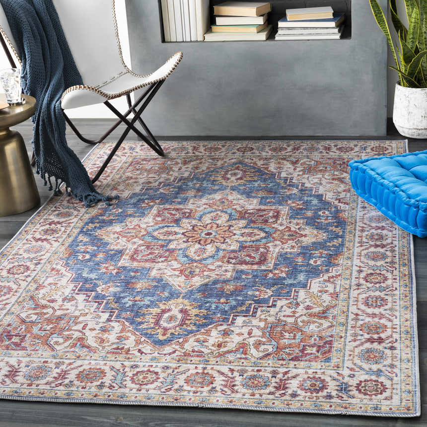 Living room scene with a Kapaa Blue Medallion Rug, white chair, blue throw, gold side table, and blue floor cushion. Roomscene-Rectangle