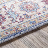 Close-up of the Kapaa Blue Medallion Rug showing beige, blue, and burgundy floral pattern and machine-woven texture. Texture