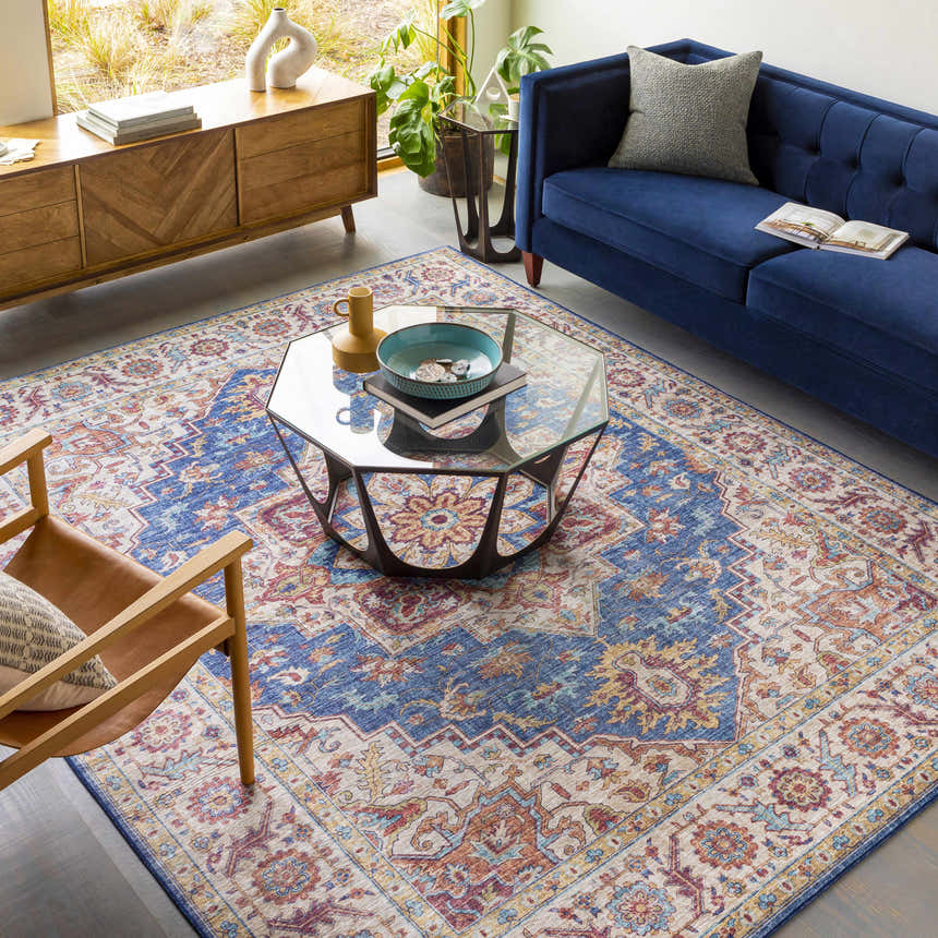 Living room with blue sofa, wood cabinet, and Kapaa Blue Medallion Rug. The rug features beige, blue, and orange traditional patterns. Roomscene-Rectangle