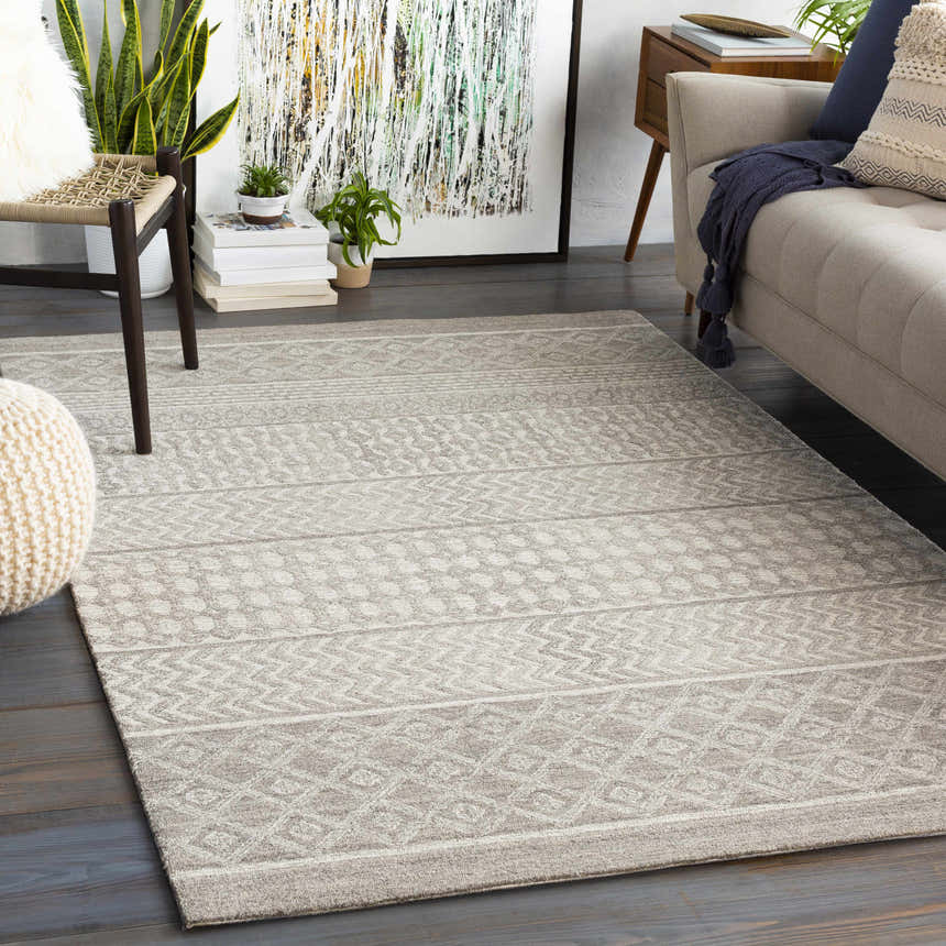 Living room scene with a Lone Beige Tufted Maroc Wool Rug, sofa, chair, plants, and art. Bohemian, neutral tones. Roomscene-Rectangle