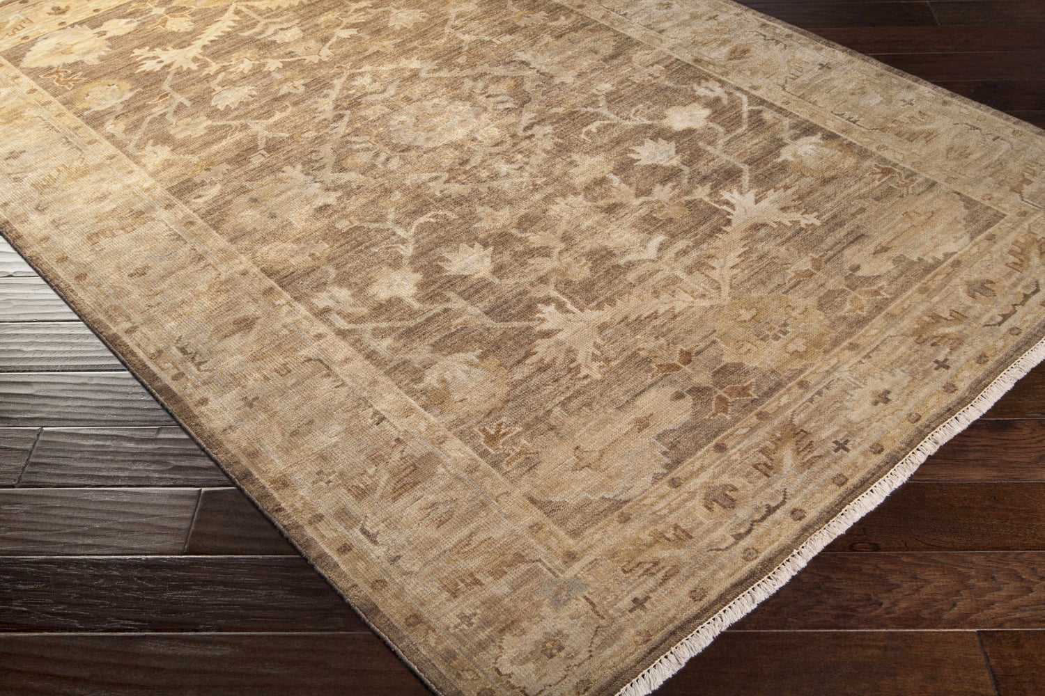Close-up of the Lochmaben Premium Wool Rug showing its traditional floral pattern and neutral colors on dark wood flooring. Corner