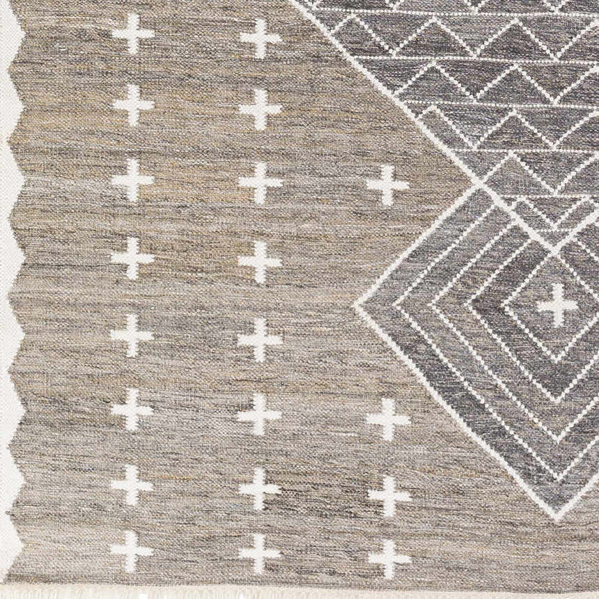 Close-up of Lodwar Area Rug, showing charcoal, cream, and gray geometric and cross pattern, hand woven texture. Swatch
