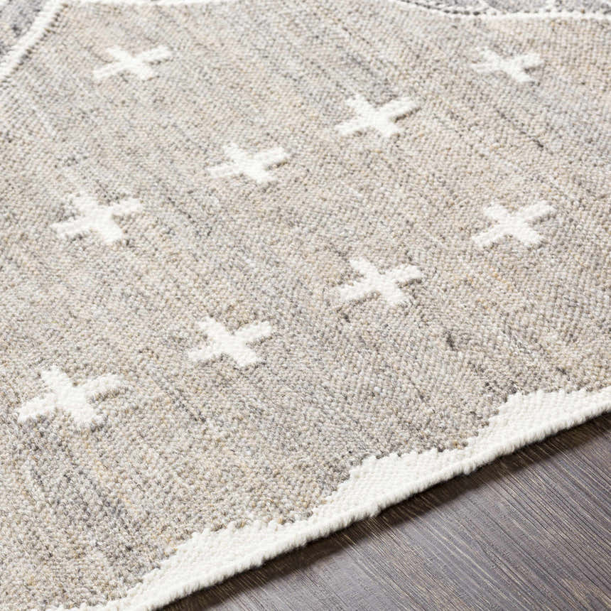 Close-up of the Lodwar Area Rug. Hand-woven rug in charcoal, cream, and gray with a geometric plus sign pattern. Texture