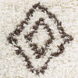 Close-up of the shag Lothian Area Rug. Ivory wool with a charcoal diamond pattern. Hand woven texture. Swatch