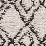 Close-up of the Lothian Area Rug showing charcoal diamond pattern on ivory wool shag texture. Swatch