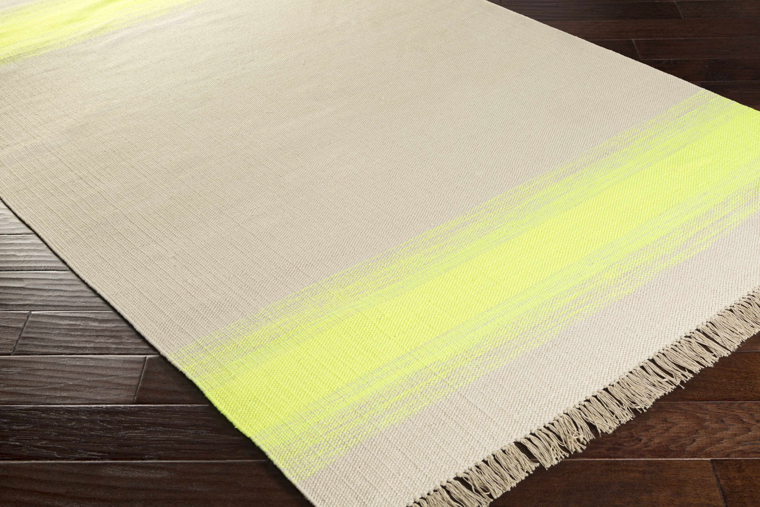 Close-up of the hand-woven Louise Area Rug. Seafoam and yellow stripes on a neutral background with fringe detail. Corner
