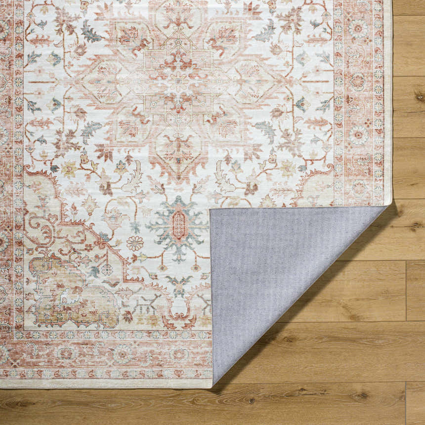 Close-up of the Lotan Pink Medallion Washable Area Rug showing its farmhouse style pattern and non-slip backing. Fold