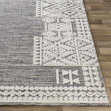 Close up of the Luddenham textured outdoor rug. Gray rug with white geometric farmhouse pattern. Front