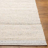 Close-up of the hand-woven Lumatil Area Rug. Jute and wool rug in cream, light gray, and beige with a black border. Front