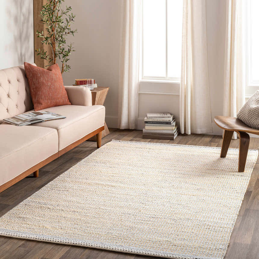 Living room scene with a light beige Lumatil Area Rug, sofa, and wood accents. Roomscene-Rectangle