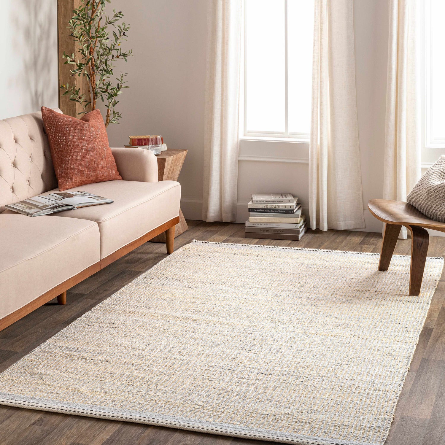 Living room scene with a light beige Lumatil Area Rug, sofa, and wood accents. Roomscene-Rectangle