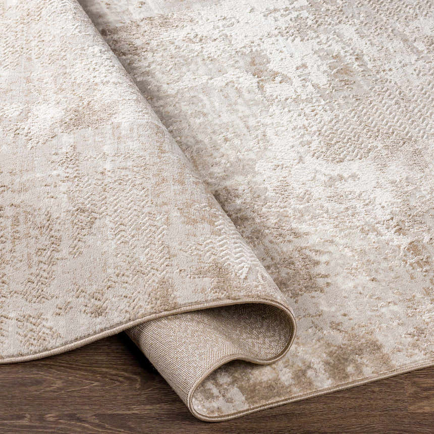 Close-up of the Lumbia Distressed Embossed Area Rug. Features a textured, abstract pattern in neutral beige and cream tones. Fold