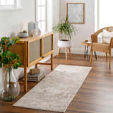 Living room scene with a Lumbia Distressed Embossed Area Rug, wood floors, console table, plants, and wicker chair. Roomscene-Runner