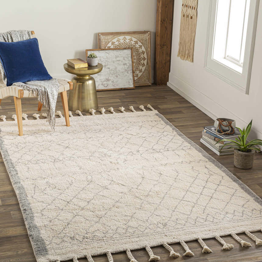 Styled room featuring the Luncarty Area Rug. Cream rug with gray geometric pattern and tassels in a neutral, farmhouse-style space. Roomscene-Rectangle