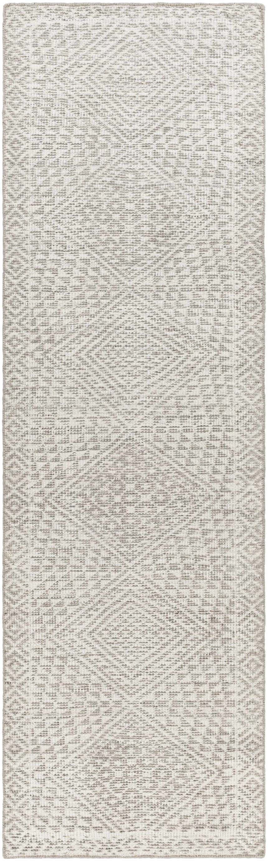 Close-up of the Lusacan Area Carpet. Hand-knotted rug in charcoal, gray, and off-white with a geometric, diamond pattern. Design-Runner-268
