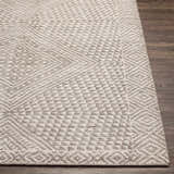 Close-up of the hand-knotted Lusacan Area Carpet. Charcoal, gray, and off-white geometric pattern. Viscose texture. Front