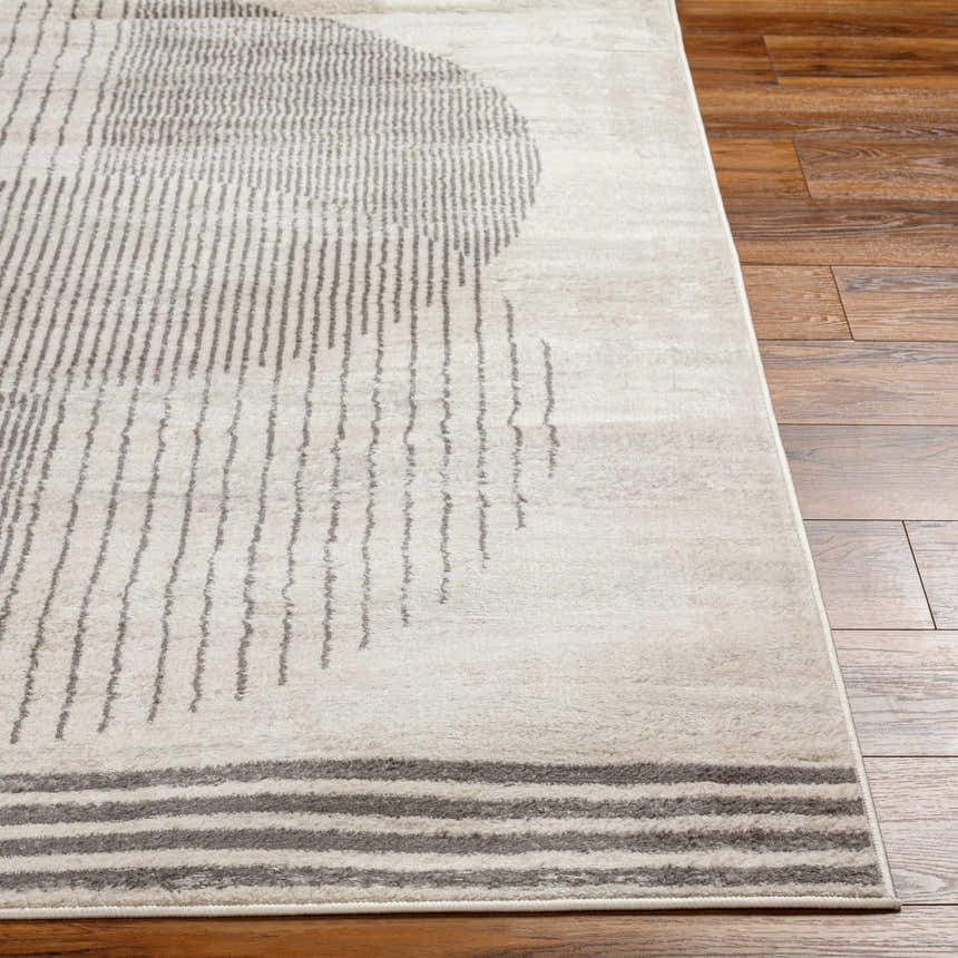 Close up of the Elvi Area Rug in natural gray with a geometric pattern on a wood floor. Front