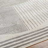 Close up of Elvi Area Rug showing its gray geometric pattern and soft texture on wood floor. Texture