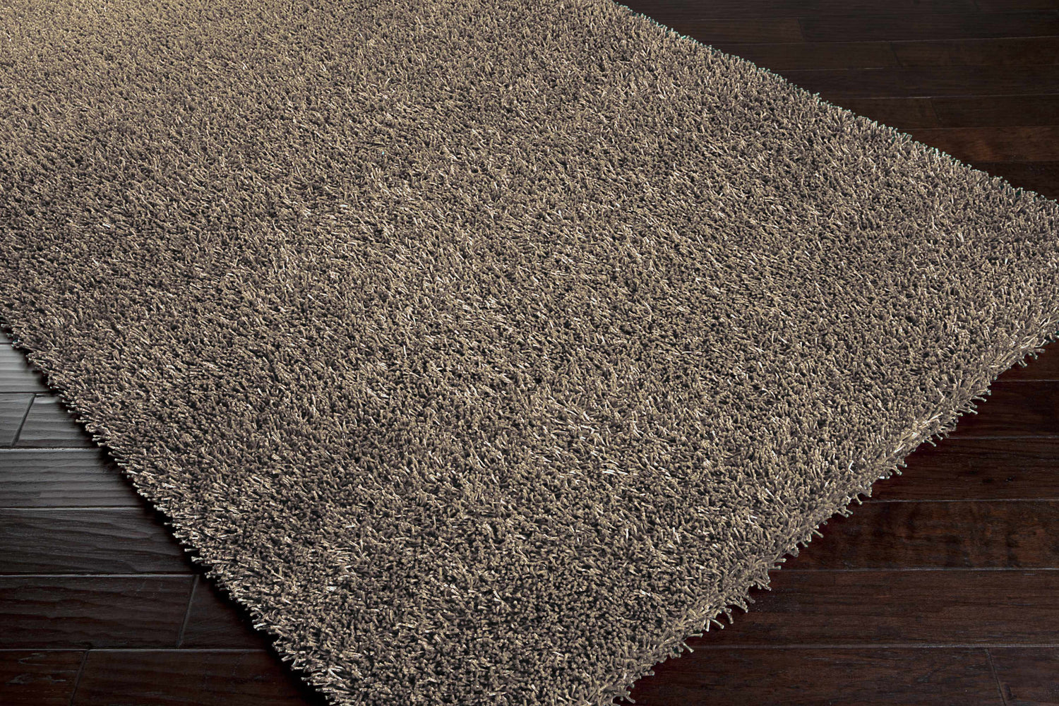 Close-up of the charcoal Morris Area Rug showing its soft, hand-woven texture on dark wood floors. Contemporary style. Corner