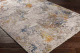 Close-up of Macayug Area Carpet. Contemporary style with cream, blue, gray, mustard, and rust colors. Machine woven polyester rug. Corner