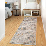 Bedroom scene with Macayug runner rug in cream, blue, and rust. Contemporary style on wood floor, bench and bed visible. Roomscene-Runner
